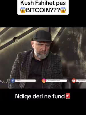 A medium shot of a man in a dark suit and a black cap, with a serious expression, is framed in front of a blurred background, possibly a studio setting. Text overlays include a question about Bitcoin. The lower section features social media branding and text in a contrasting font, indicating an informational or discussion-based content.