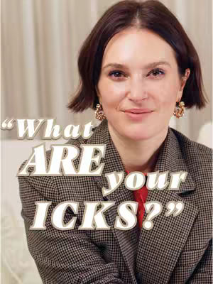 A woman is centered in a medium shot. The woman is wearing a blazer over a red shirt with eye-catching earrings that match her expression. The background appears to be a creamy, soft color. Large text overlays on the image. 
