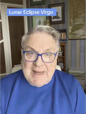 An older man with glasses and a blue shirt is centered in the frame, looking directly at the camera and talking. A text box with the words 'Lunar Eclipse Virgo' is in the top left corner.