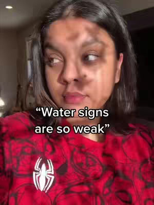 The cover image features a close-up shot of a person, whose face takes up most of the frame. The individual, likely the creator, is looking off to the side with a thoughtful expression. Text overlayed on the image reads, "Water signs are so weak!" The background appears to be a domestic setting, possibly a room in a house. The person is wearing a red Spider-Man shirt.