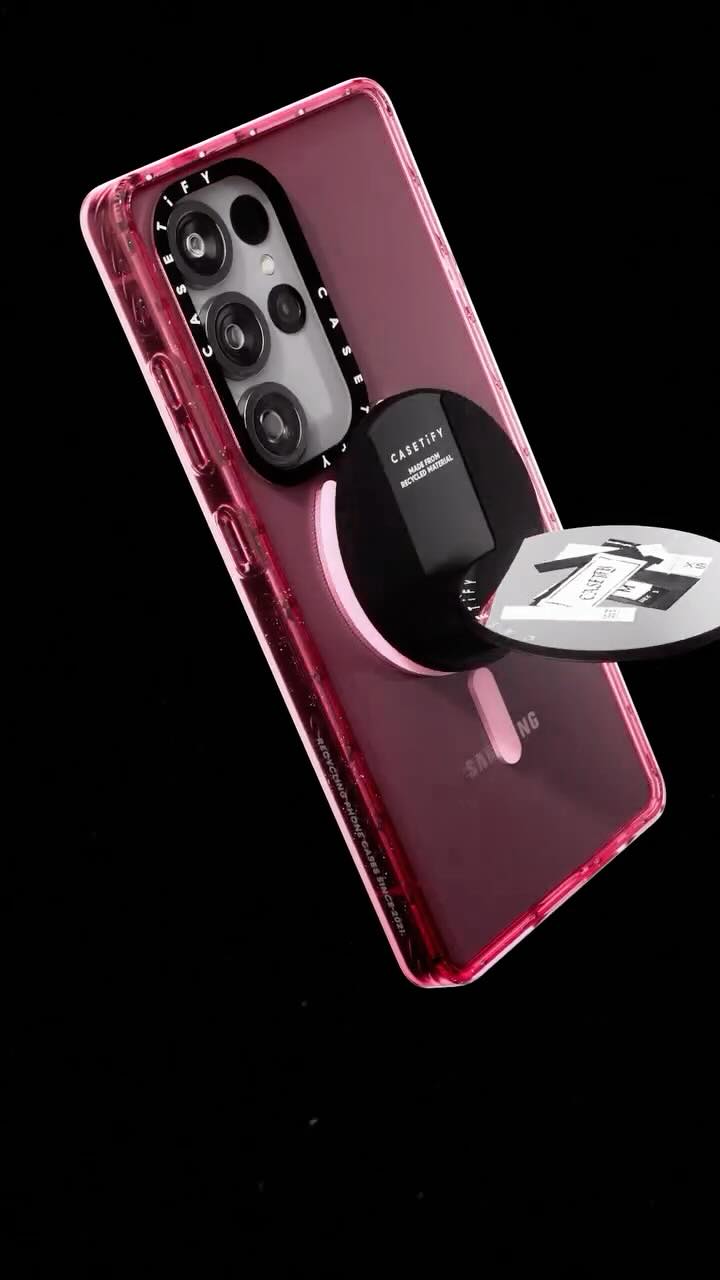 The image shows a smartphone case with a phone inside against a black background. The case is transparent with a pinkish tint. A black magnetic attachment is on the back of the phone. A secondary magnetic disk is floating to the side, displaying a case label. The phone's camera lenses are visible through cutouts in the case. The brand CASETiFY is featured.