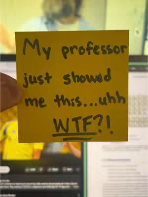 A person's hand holds a yellow sticky note over a screen displaying an image of a person speaking, likely from a video. The note, centered and the main focus, features handwritten text in black marker.