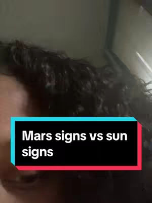 The cover image features a partial view of a person's face and dark, wavy hair. A rectangular text overlay at the bottom contains the phrase "Mars signs vs sun signs" in white text against a black background, framed by a light turquoise border. The background appears to be a neutral color, perhaps an indoor setting.