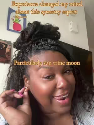 The cover image is a selfie of a Black woman with long, braided hair. She's looking towards the right side, with her mouth slightly open as if speaking. She is touching her ear, possibly adjusting an earring, and the background shows a domestic interior, with images on the wall.