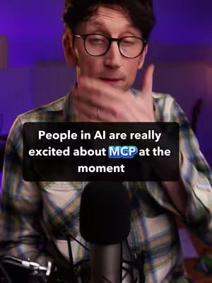A man with glasses is speaking into a microphone. Overlayed on the image is a black box with the text 'People in AI are really excited about MCP at the moment'. The man is wearing a plaid shirt and there is purple lighting in the background.