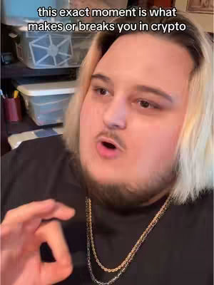 A close-up shot of a man with blonde-streaked hair, wearing a black shirt and gold chains, gesturing with his hand while speaking. Text overlay at the top.