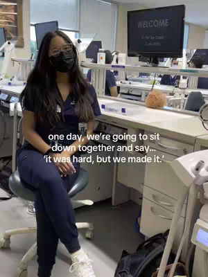 A young woman wearing a face mask and glasses sits on a chair in what appears to be a dental clinic. She is wearing scrubs and the background includes dental equipment and a computer screen with the word 'WELCOME' displayed. Text overlays the image.