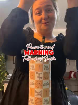 The cover image is a selfie-style video shot. The creator, a woman with light skin and medium-length hair, is positioned from the chest up. She is smiling slightly, and appears to be holding a tumbler in front of her, in a decorative sheath. The hook text, in a stylized font, reads 'Pause to read WARNING Talk about Santa'. The background is partially visible with hints of the interior decorated, The lighting appears to be warm.