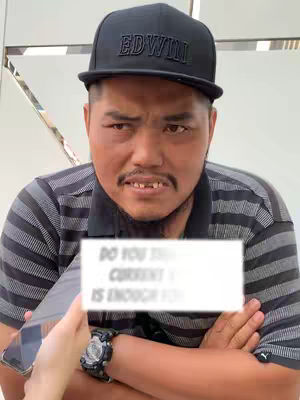 A man wearing a black cap and a striped shirt is being interviewed. Text overlaid on image indicates what the interview contains, the man has an expression that may suggest he is making a face of disbelief or surprise.