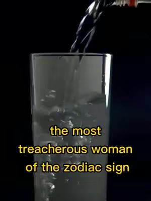 A high-angle shot of a clear glass with water being poured into it from above. The water stream is a dark color, possibly black. Below the glass is text overlayed that says "the most treacherous woman of the zodiac sign" in yellow font.