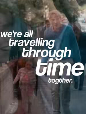 The image shows a blurry scene of people walking in an urban environment. The primary focus is on the overlaid white text that reads "we're all travelling through time together."