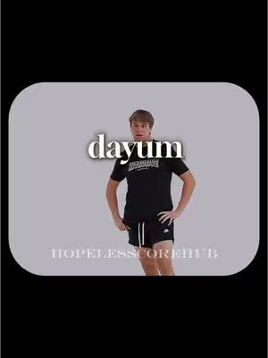 A young man with short brown hair, wearing a black t-shirt and shorts, stands with his hands on his hips against a light gray background in a vertically-oriented image. White text that reads 'dayum' is at the top, and 'HOPELESSCOREHUB' appears at the bottom in small font.