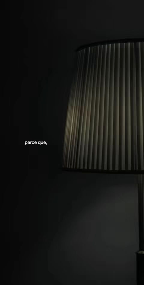 A dark, moody image with a lamp in the foreground. The lamp has a rectangular shade with vertical lines, and it is the main source of light in the image. The background is a dark wall. The text overlay is placed on the left side, written with a simple, clean font.