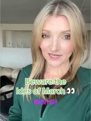 A selfie-style video cover image featuring a fair-skinned woman with blonde hair, looking directly at the camera with a slight smile. Text overlays in green and purple are superimposed on the image, with a blurred background suggesting a domestic setting. The woman is wearing a green hooded top against a softly blurred background.