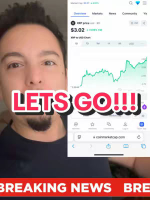A selfie-style video frame featuring a man in the foreground with a phone screen displaying a cryptocurrency chart and data. The man's face is in focus, with stylized text 'LETS GO!!!' overlaid on the image. The background displays real-time crypto data on a smart phone.