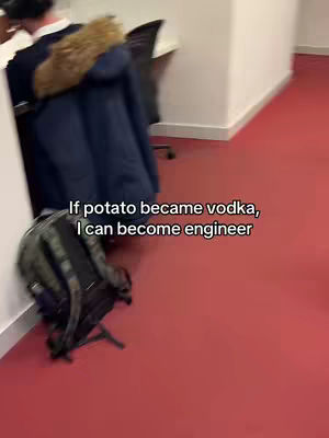 The image shows a corner of a room. A red floor contrasts with white walls and a black backpack against the wall. A person's back is visible, leaning on a navy coat with a furry collar. Text overlayed on the image reads, "If potato became vodka, I can become engineer."