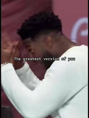 A man with short, dark hair is shown from the chest up, in front of a reddish-pink background. He's dressed in a white long-sleeve shirt. The man is bending his arms with his hands up near his head. Text overlay in white is at the bottom of the image.