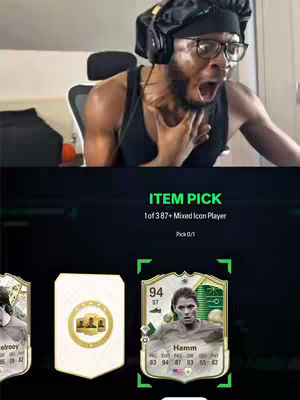 The image shows a man reacting with shock and excitement, with a video game interface visible that includes a virtual card identified as Mia Hamm, a female soccer player. The man is wearing a black head covering and headphones, and his mouth is open in an expression