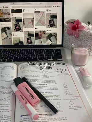 The image features a well-lit workspace with a laptop displaying a collage of images, perhaps from Pinterest. An open textbook with handwritten notes and highlighted texts sits in the foreground, along with a pink highlighter and pen. A candle and flowers are in the background adding a touch of aesthetic appeal. The composition is clean and focused on the setting, which suggests a study or workspace.