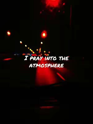 A nighttime scene viewed from inside a car. The foreground shows the car's dashboard and a glimpse of the road. The background features blurred lights from other vehicles and streetlights, with a red glow in the middle of the image. Text is overlaid in white.