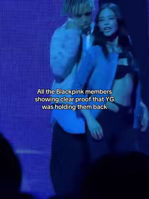 The image showcases a behind-the-scenes moment during a performance with a blue backdrop. Two individuals are partially visible, with one person holding another, appearing to be part of the ensemble. The text overlay highlights the narrative.