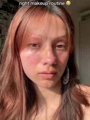 The cover image is a close-up shot of a young woman's face. She has long, reddish-brown hair and is looking directly at the camera with a neutral expression, with hints of blush on her cheeks. She has an earring on her right side. The background is out of focus and slightly illuminated from what seems like a window's light.