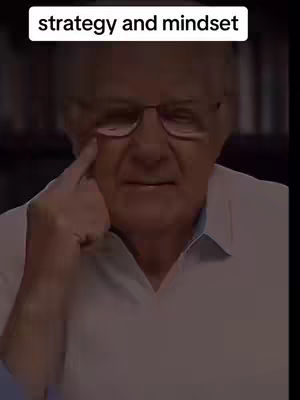 An older man wearing glasses is looking towards the camera, touching his right eye with his index finger, his expression is serious. The man is wearing a white button-down shirt. Above his head, a white rectangular text overlay says 'strategy and mindset'.