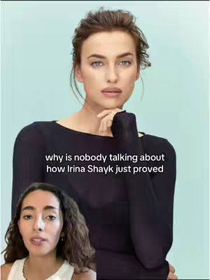 The image shows two women. The main focus is on a woman with a slight smile, fair skin, and light-colored hair styled up, posing with her hand near her chin. The background is a pale turquoise color. In the lower left corner, another woman is visible, looking towards the main subject, with dark hair. Overlayed text reads, 'why is nobody talking about how Irina Shayk just proved'.