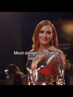 Red-haired woman with fair skin in a sequined top, smiling. Text overlayed in a black box against the background, and blurred people in the background.