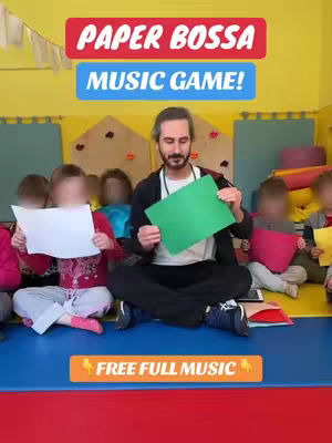 A man sitting cross-legged on a blue surface holds a green piece of paper, with several children positioned around him, each facing away. Overlaid are text blocks and a banner, with a yellow wall and various items in the background.