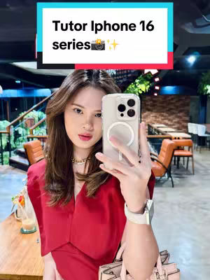 A selfie-style image featuring a young woman holding a smartphone, likely taking the photo. She is dressed in a red dress and is positioned indoors with a blurred background. Text at the top of image overlays, in a rectangle of teal blue at the top frame.