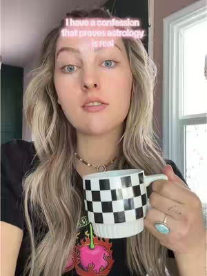 A woman with long blonde hair is holding a black and white checkered mug. She's wearing a black shirt and a necklace. There's text overlaid on the image.