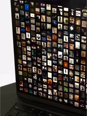 A laptop screen displaying a collage of images, likely a mood board. The laptop is open on a desk, with the keyboard in the foreground. The screen is filled with small, square images arranged in a grid.