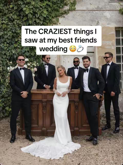 A group of six people, including a bride in a white gown, and five men in black suits, are posing for a photo. The bride is centrally positioned and framed by the men, all of whom are wearing sunglasses and appear to be in a formal setting. A text overlay states, 'The CRAZIEST things I saw at my best friends wedding', adding context.