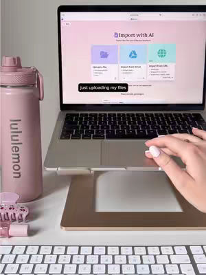 The video shows a laptop open on a stand, with a pink water bottle and a keyboard in the foreground. The laptop screen displays a presentation software interface with options for uploading files. The overall aesthetic is clean and modern.