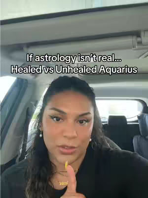 A woman is inside of a car, facing the camera and speaking, with text overlayed. The text says, 'If astrology isn't real... Healed vs Unhealed Aquarius.' The woman has long, dark hair. Her finger is pointed towards the camera.