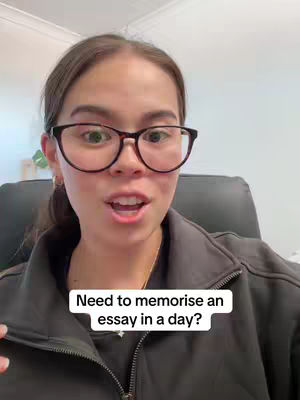 A front-facing shot of a young woman with brown hair and glasses. A white text box at the bottom reads "Need to memorise an essay in a day?"