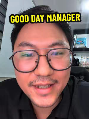 A close-up shot of a man wearing glasses, smiling at the camera. The image has a yellow text overlay that reads 'GOOD DAY MANAGER'. The background is slightly blurred.