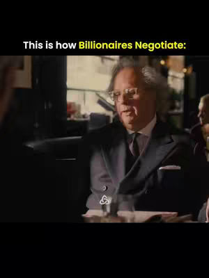 A man with grey hair, wearing glasses and a dark suit, is speaking at a table. Text overlaid on the image says, "This is how Billionaires Negotiate:"