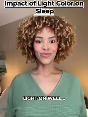 A woman with light skin and curly brown hair smiles at the camera. She is wearing a green sweater, and the background is a softly lit room. Text overlays read "Impact of Light Color on Sleep" at the top and "LIGHT ON WELL..." at the bottom.