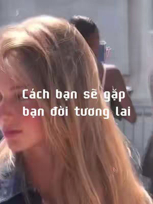 A woman with long blonde hair is in the foreground with a blurred background that suggests an outdoor setting. Text overlayed in white font reads: \"Cách bạn sẽ gặp bạn đời tương lai\". The composition is focused tightly on the woman, and the overall color palette is soft with natural lighting.