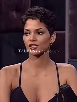 The cover image is a medium shot featuring Halle Berry, positioned in a studio setting. She has short, dark hair and is looking towards the camera with a slightly opened mouth. The background appears blurred, and the lighting is moderate. The bottom portion of a microphone is visible, suggesting an interview setting.