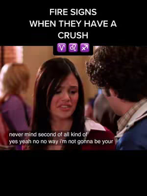 A screenshot from the show 'The O.C.' featuring a woman with long dark hair and a man, both facing each other in a room. Text overlays read 'FIRE SIGNS WHEN THEY HAVE A CRUSH' and a line of zodiac symbols. The woman appears distressed, and text at the bottom states a phrase.