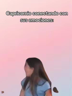 The cover image has a soft, blurred pink and white gradient background. In the foreground, a person with long brown hair is partially visible, their face turned away, expressing an emotion which may be surprise or distress. The overlay text at the top says 'Capricornio conectando con sus emociones:'