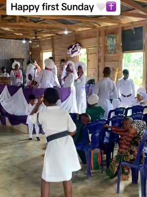 A diverse group of people in white garments in a church setting, with a person in the foreground wearing white and a black belt.