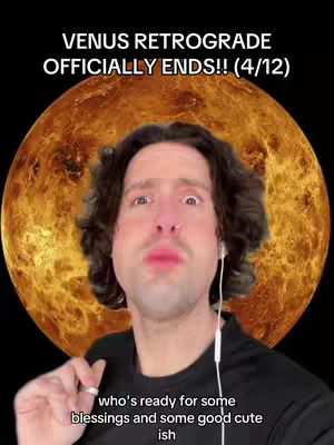 A man with brown curly hair and a nose ring is centered in front of a golden, planet-like background. Text overlays: "VENUS RETROGRADE OFFICIALLY ENDS!!(4/12)" at the top, and "who's ready for some blessings and some good cute ish" at the bottom. The man is looking up with a slightly pursed lip, his right index finger pointing up, holding onto an earbud cord.