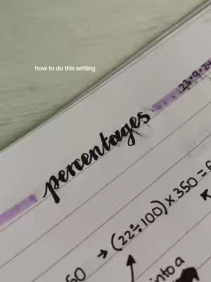 The image shows a close-up of a notebook open to a page with handwritten notes. The word "Percentages" is written in a stylized, flowing font. Below, mathematical calculations are visible with arrows and symbols. The background appears to be a soft, off-white surface, possibly fabric or a desk.