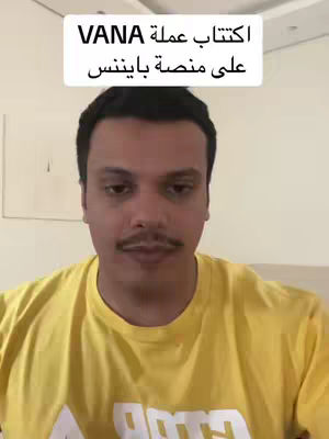 A man with a mustache is centered in the frame, wearing a yellow t-shirt. Above him is a white rectangular text box that displays a title in Arabic script. The background is a plain wall.