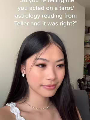 A close-up shot of a young woman with long, dark hair and Asian features. She's looking slightly to the side with a subtle smile, wearing a white top with a ruffled edge and a delicate pearl necklace, and stud earrings. The background is a light-colored wall, with text overlayed.