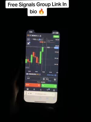 A phone displaying a trading app interface is held up in front of a black background. There is an overlay at the top that has white text on a black background. The phone displays a chart of numbers with red and green bars.